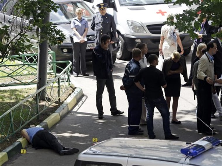 Police officers and investigators stand near the body of ex-policeman Yuri Budanov in Moscow on Friday. 
